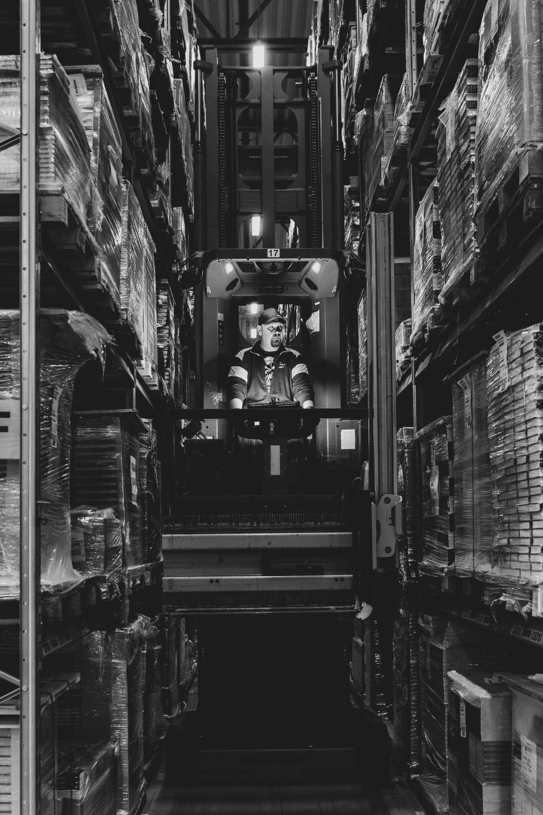 A forklift operator in a warehouse aisle