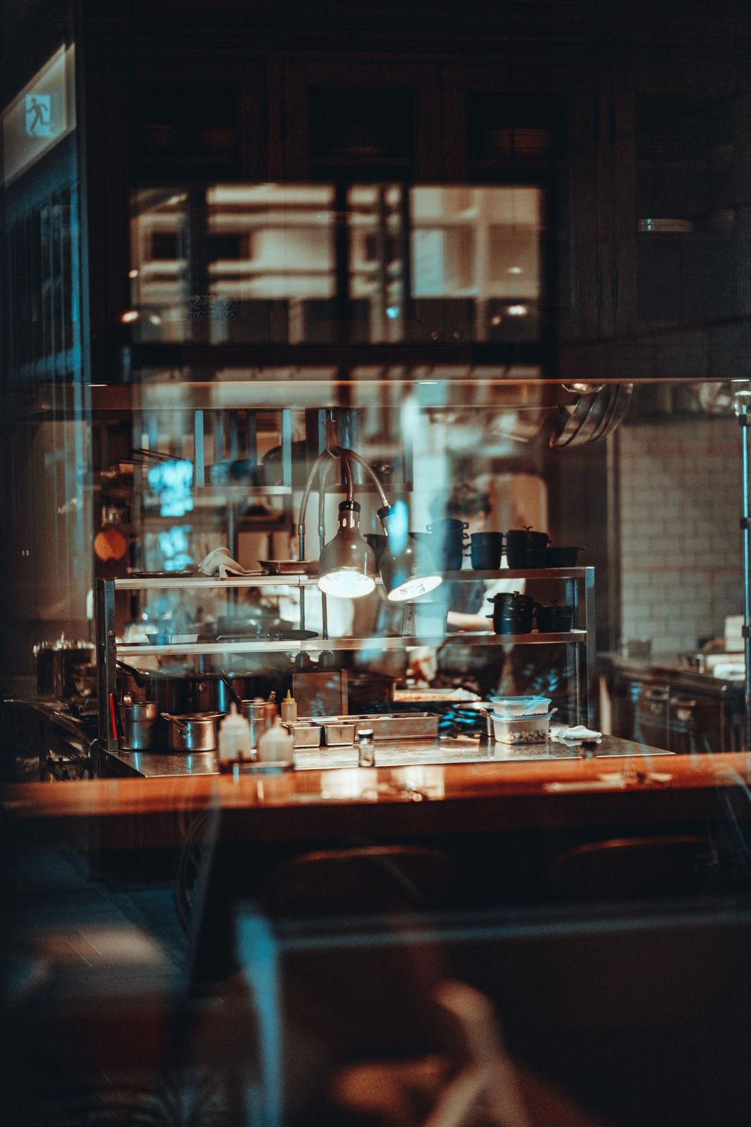 A restaurant kitchen seen through the window at night